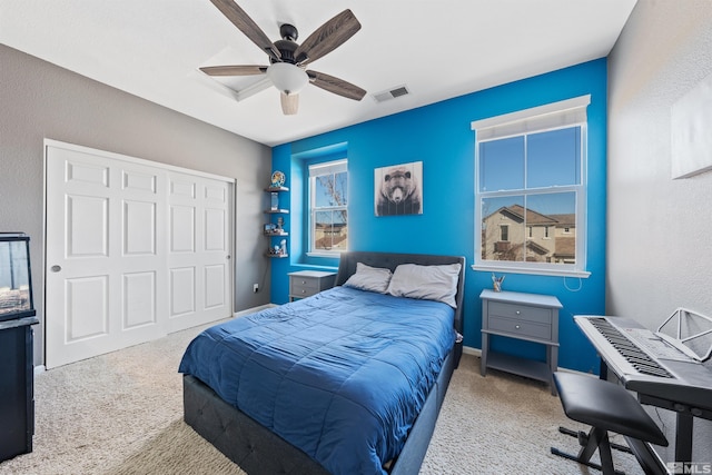 carpeted bedroom featuring ceiling fan and a closet