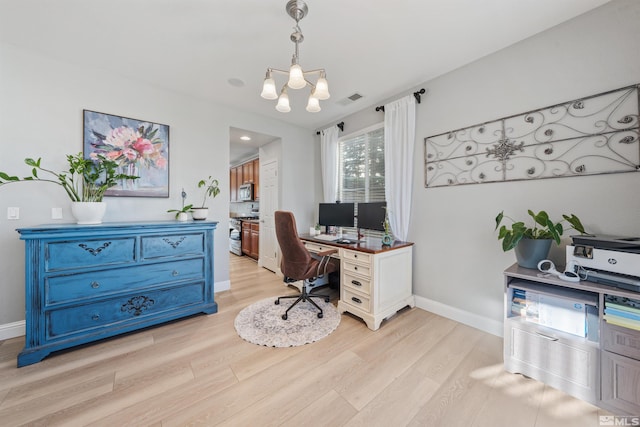 office with light wood-type flooring and an inviting chandelier