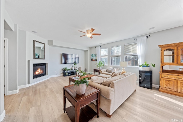 living room featuring light hardwood / wood-style floors, ceiling fan, and wine cooler