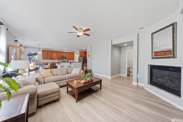 living room featuring light wood-type flooring and ceiling fan