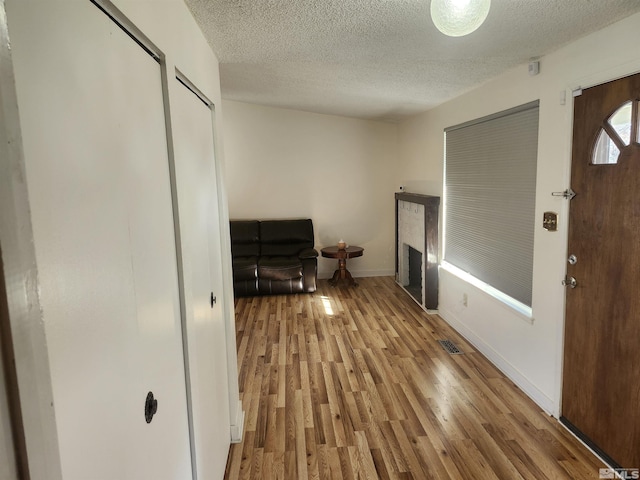 foyer entrance with a textured ceiling and light wood-type flooring