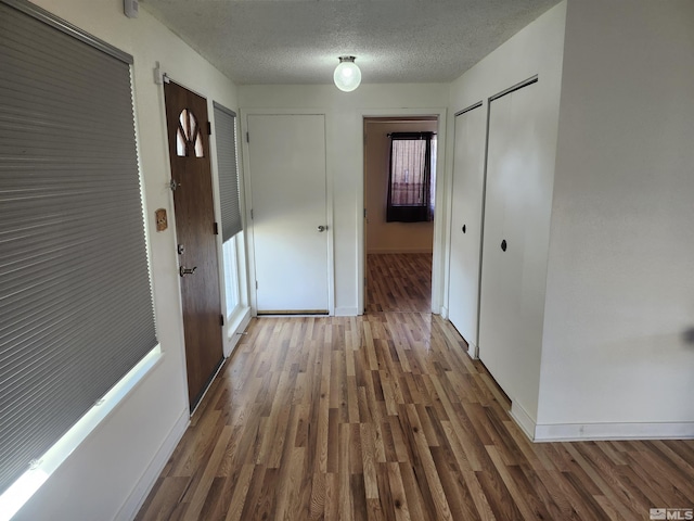 hallway featuring dark hardwood / wood-style flooring and a textured ceiling