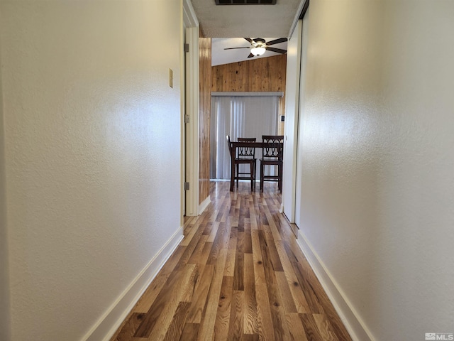 hall featuring wood-type flooring and lofted ceiling