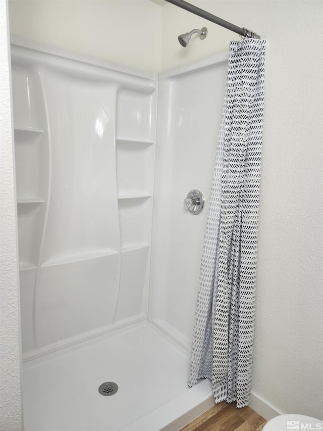 bathroom with a shower with curtain and hardwood / wood-style flooring