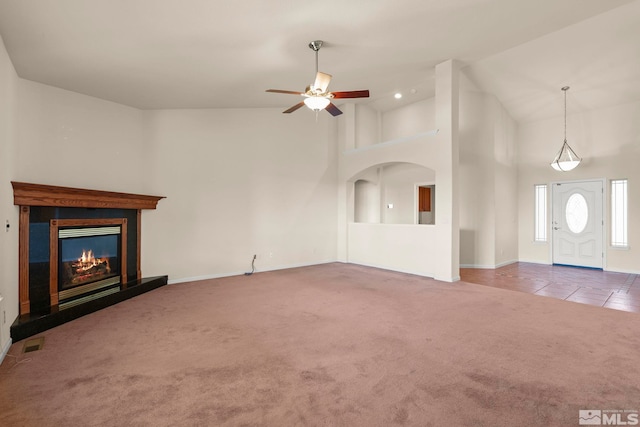 unfurnished living room featuring high vaulted ceiling, ceiling fan, and carpet floors