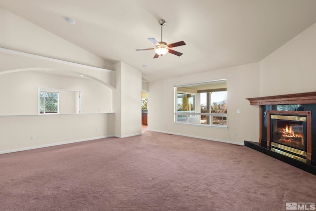 unfurnished living room with ceiling fan, vaulted ceiling, a fireplace, and carpet floors