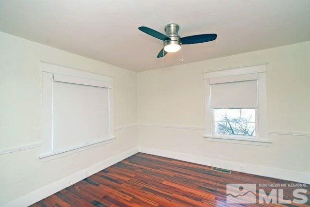 spare room with dark wood-type flooring and ceiling fan