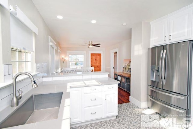 kitchen with ceiling fan, sink, light tile patterned floors, stainless steel fridge with ice dispenser, and white cabinets