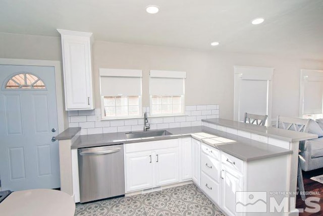 kitchen with sink, white cabinets, stainless steel dishwasher, and kitchen peninsula