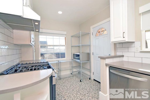 kitchen featuring appliances with stainless steel finishes, white cabinetry, and tasteful backsplash