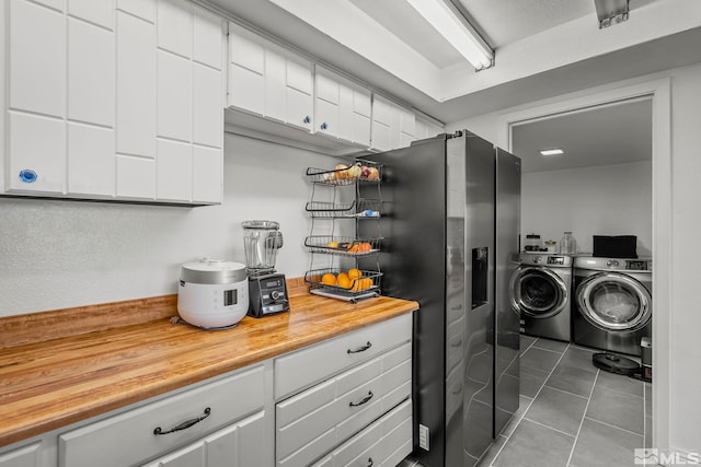 clothes washing area with dark tile patterned flooring and separate washer and dryer