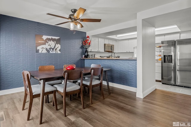 dining space with ceiling fan and light hardwood / wood-style floors