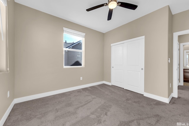 unfurnished bedroom featuring ceiling fan, a closet, and light carpet