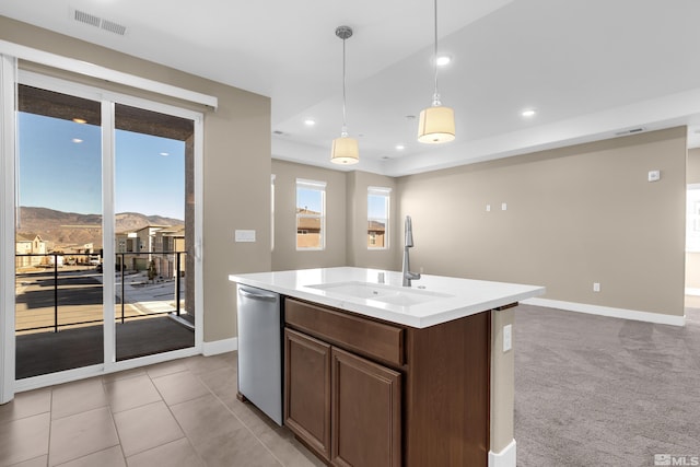 kitchen with a mountain view, decorative light fixtures, a kitchen island with sink, stainless steel dishwasher, and sink