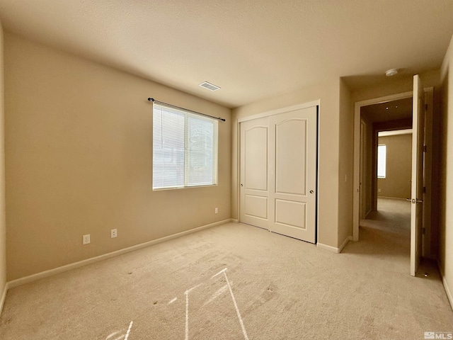 unfurnished bedroom featuring a closet and light carpet