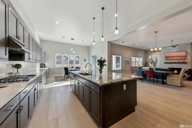 kitchen featuring sink, stainless steel appliances, a kitchen island with sink, and pendant lighting