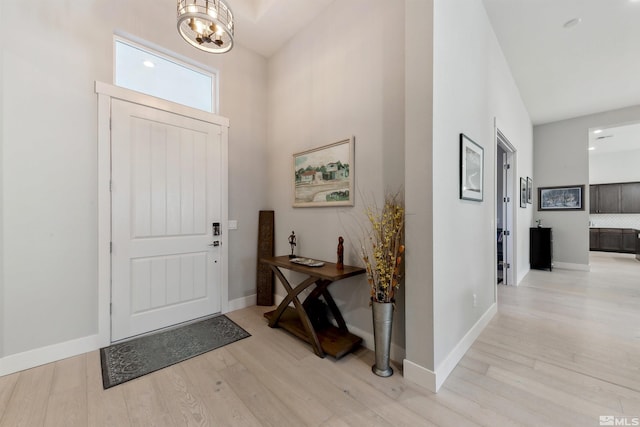 entryway with light wood-type flooring and a chandelier