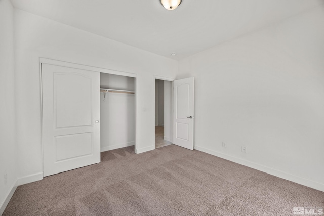 unfurnished bedroom featuring carpet flooring and a closet