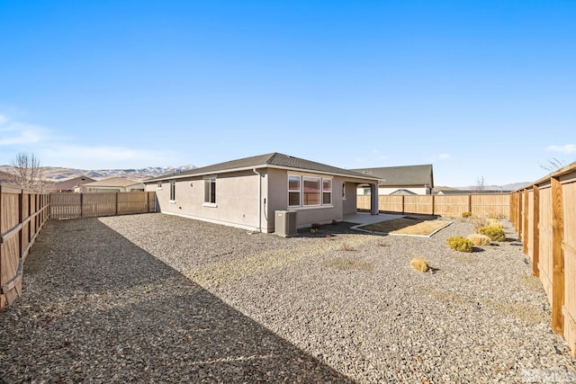 rear view of house with a mountain view, cooling unit, and a patio area