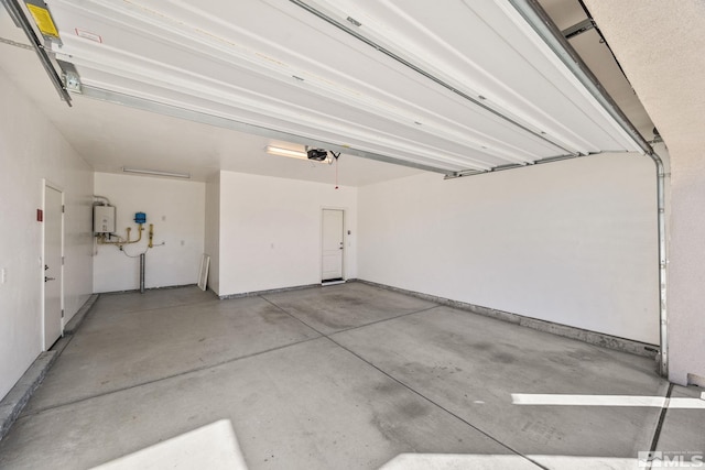 garage featuring tankless water heater and a garage door opener