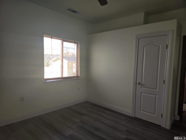 empty room featuring ceiling fan and dark hardwood / wood-style flooring