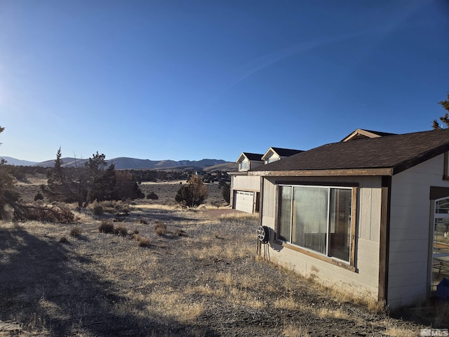 view of yard featuring a mountain view and a garage