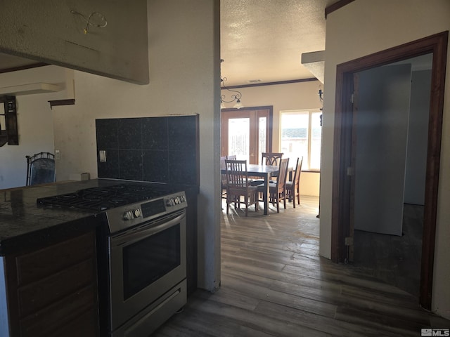 kitchen with a textured ceiling, stainless steel gas range, and dark hardwood / wood-style flooring