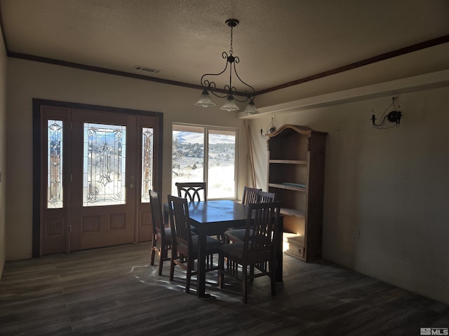 dining area with crown molding, dark wood-type flooring, and a textured ceiling