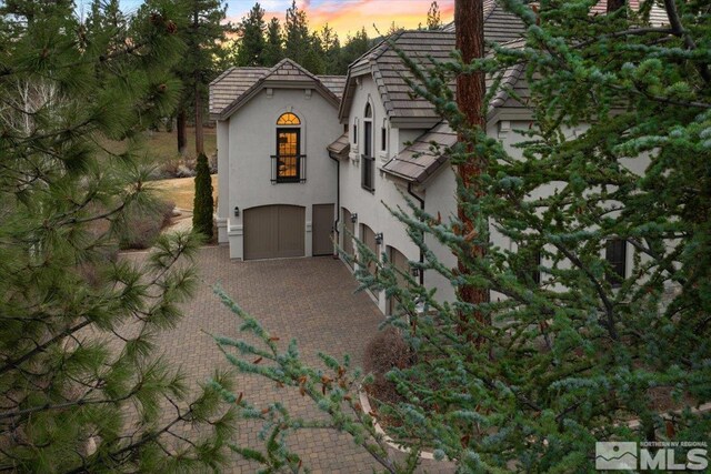 property exterior at dusk featuring a garage