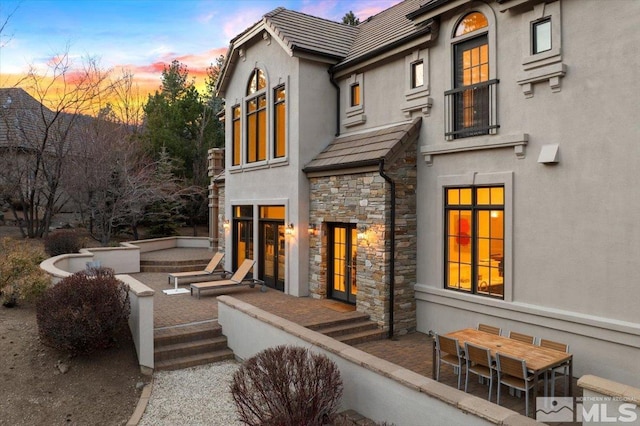 back house at dusk with a patio