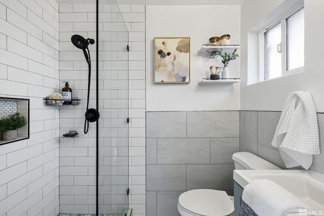 bathroom featuring tile walls, toilet, and tiled shower