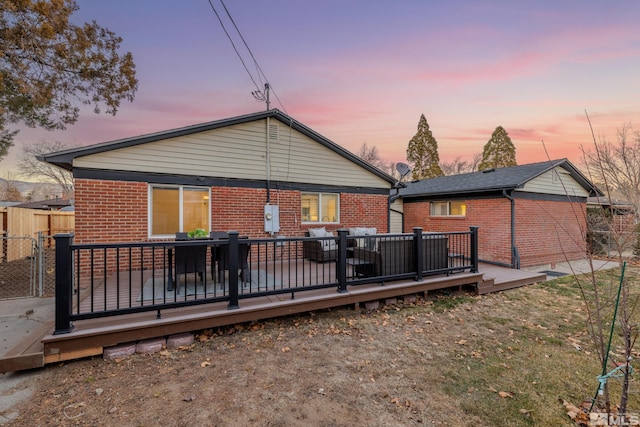 back house at dusk with a deck