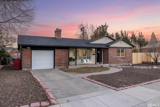 ranch-style house featuring covered porch and a garage