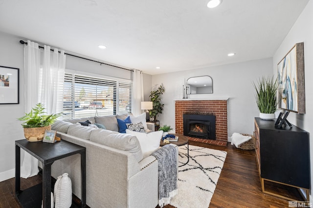 living room featuring dark hardwood / wood-style floors and a brick fireplace