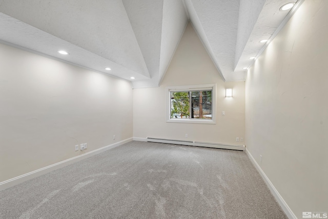 unfurnished room with carpet, a textured ceiling, vaulted ceiling, and a baseboard heating unit