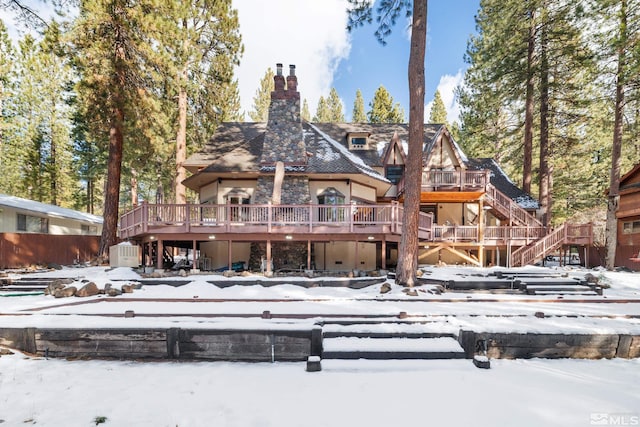 snow covered property with a wooden deck