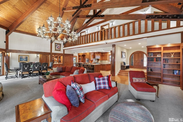 carpeted living room featuring beam ceiling, high vaulted ceiling, and a notable chandelier