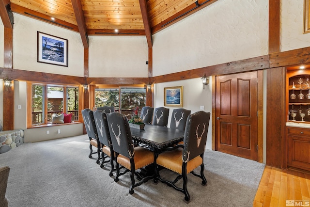 dining area with wood ceiling, high vaulted ceiling, beam ceiling, and light carpet