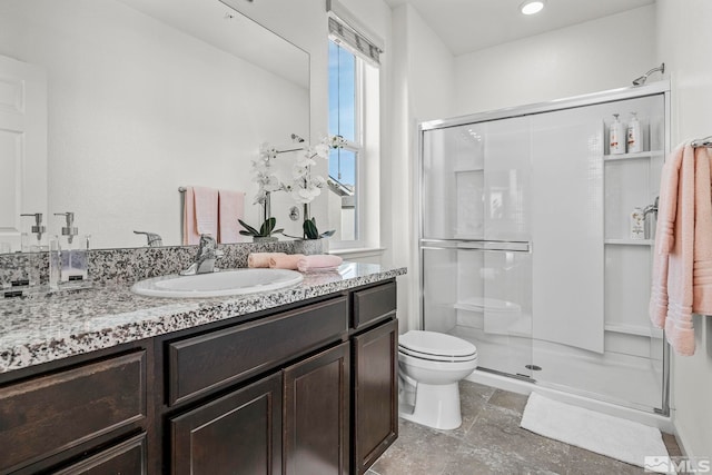 bathroom with toilet, vanity, and walk in shower