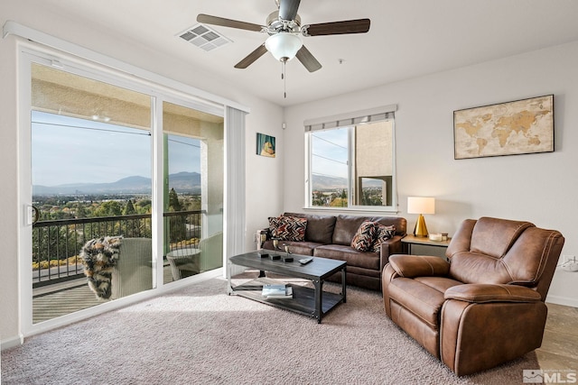 living room with a mountain view and ceiling fan