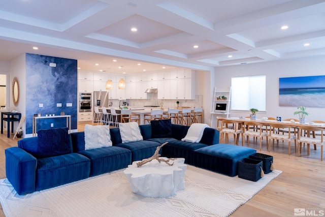 living room featuring beamed ceiling, coffered ceiling, and light wood-type flooring