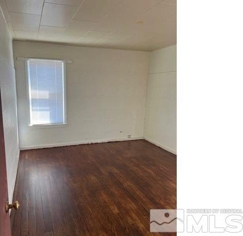 spare room with dark wood-type flooring