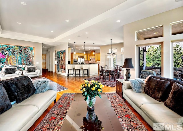 living room featuring a chandelier and light wood-type flooring