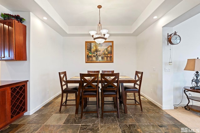 dining room featuring a chandelier and a tray ceiling