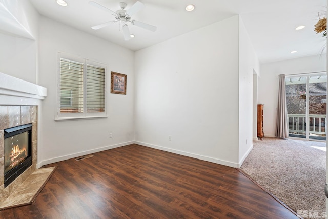 unfurnished living room with ceiling fan, dark hardwood / wood-style floors, and a fireplace