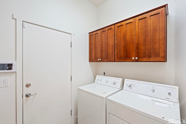 laundry room featuring separate washer and dryer and cabinets