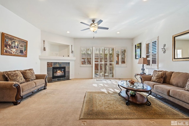 living room featuring ceiling fan, light colored carpet, and a fireplace