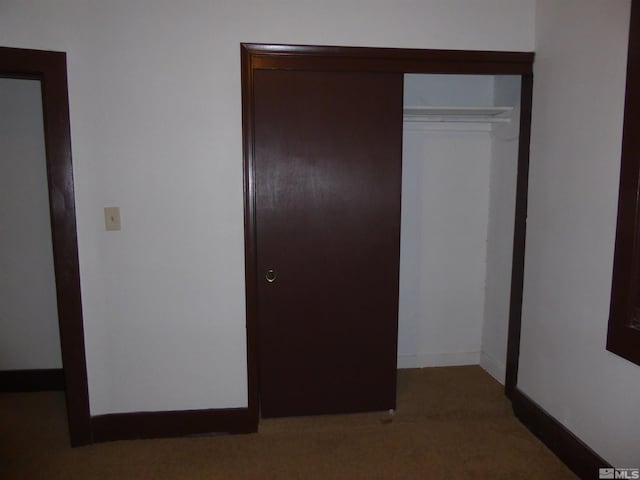 unfurnished bedroom featuring carpet and a closet