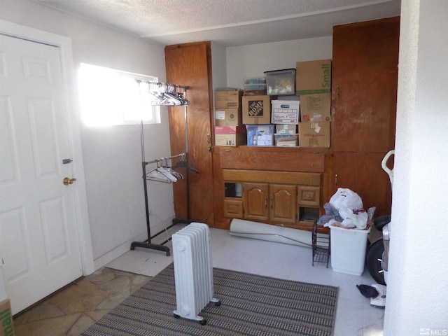 bathroom featuring a textured ceiling and radiator heating unit