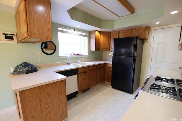 kitchen featuring black refrigerator, white dishwasher, and sink